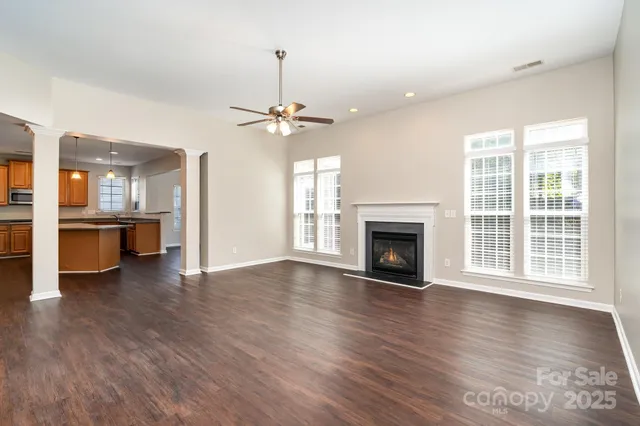 wooden floor fireplace and windows in an empty room