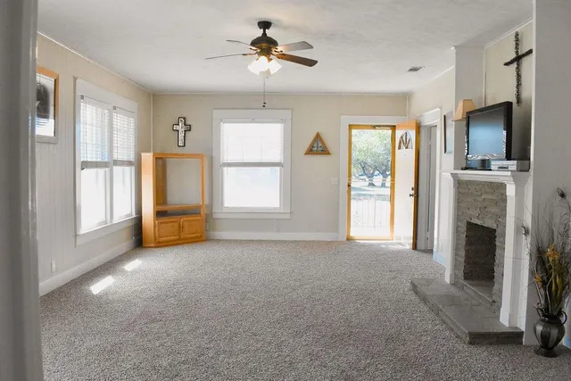 a view of empty room with windows and fireplace