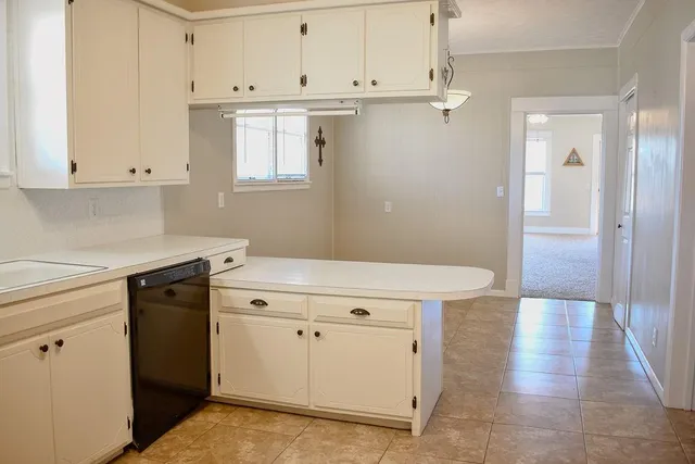 a kitchen with granite countertop white cabinets and white appliances