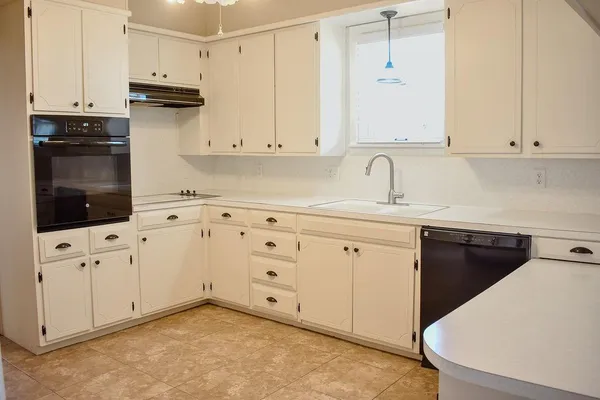 a kitchen with granite countertop white cabinets and stainless steel appliances