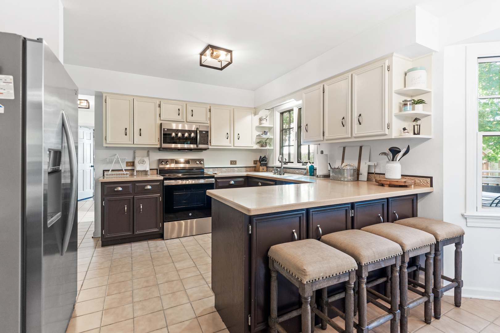 560 Renee Court Geneva, IL 60134 - Photo 16 of 50 a kitchen with stainless steel appliances granite countertop a stove a refrigerator a sink a dining table and chairs