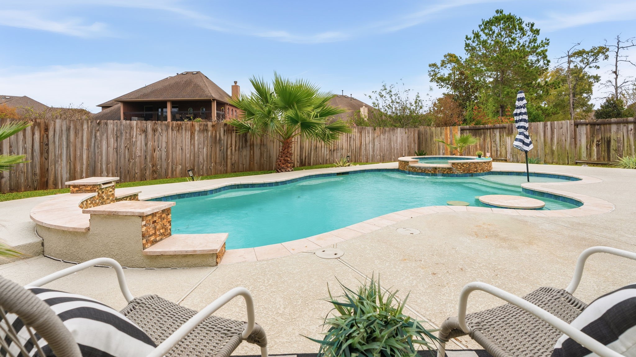 307 Arbor Ridge Lane Conroe, TX 77384 - Photo 42 of 50 a view of a backyard with table and chairs potted plants and wooden fence