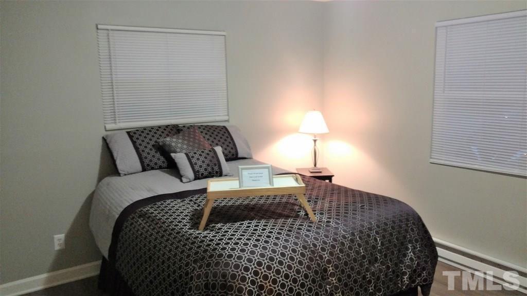 411 Rose Lane Raleigh, NC 27610 - Photo 9 of 12 a bedroom with a bed and a lamp