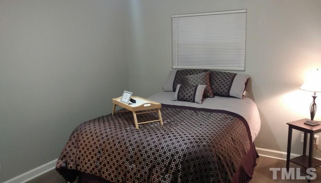 411 Rose Lane Raleigh, NC 27610 - Photo 10 of 12 a bedroom with a bed and a chair