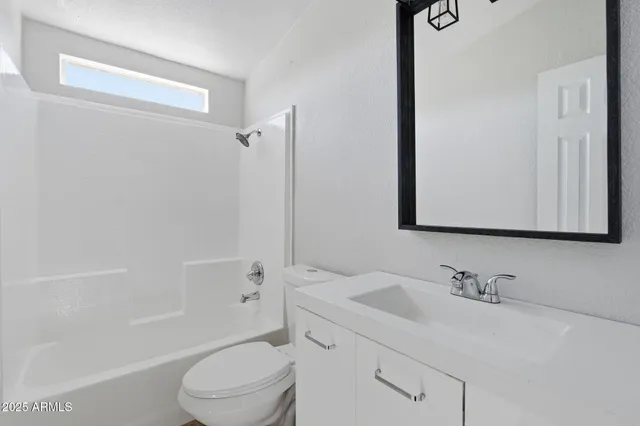 a bathroom with a granite countertop sink a toilet and shower