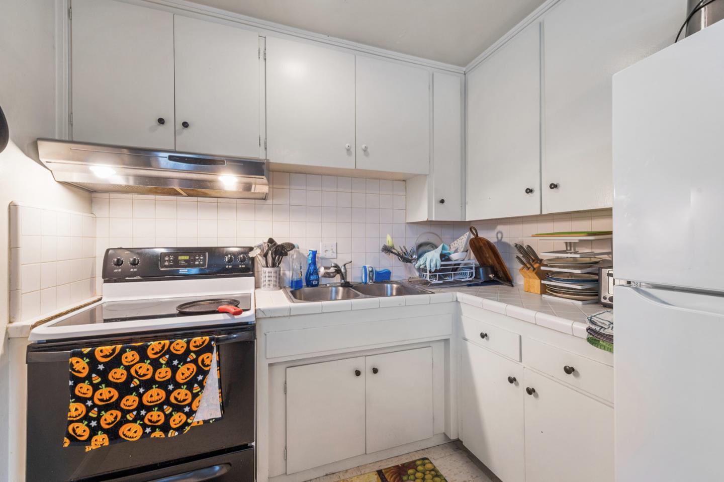 1830 48th Avenue Capitola, CA 95010 - Photo 10 of 32 a kitchen with stainless steel appliances a white cabinets and a stove top oven