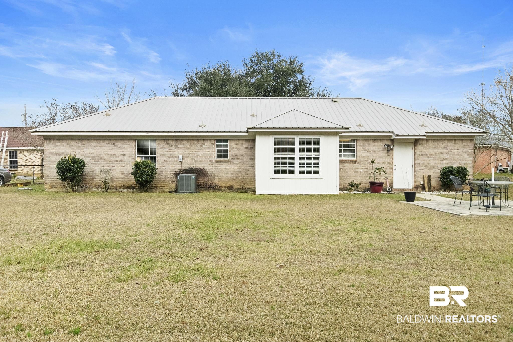 14031 Brook Hollow Road Summerdale, AL 36580 - Photo 45 of 56 Back of house with a lawn, a patio area, and central AC