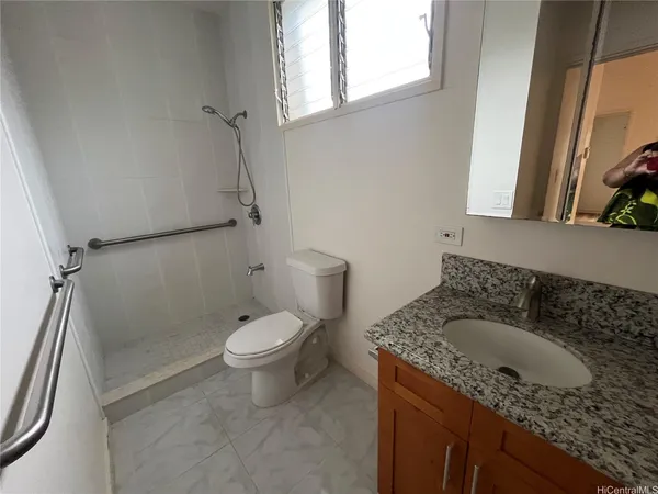 a bathroom with a granite countertop sink a toilet and a shower