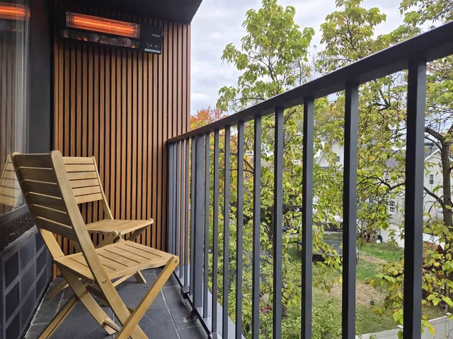 a view of a balcony with chair and wooden floor