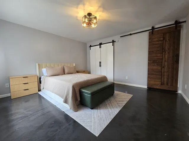 a spacious bedroom with a bed and a chandelier