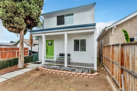 a view of a house with a small yard and wooden floor and fence