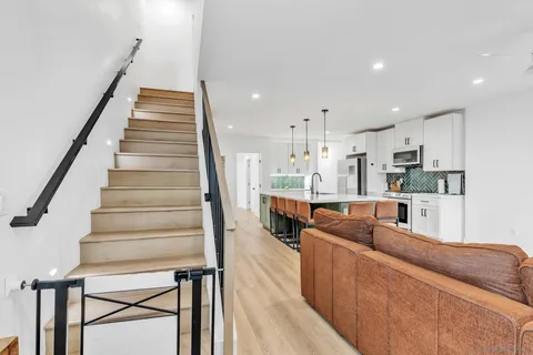 a living room with furniture and a dining table with wooden floor
