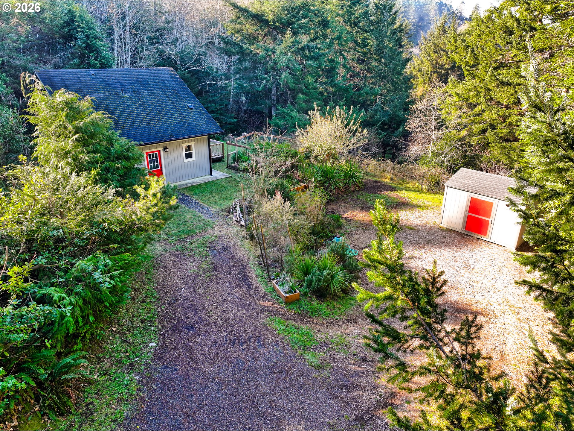 94516 Riley Creek Way Gold Beach, OR 97444 - Photo 2 of 35 a view of a house with a yard and a bench