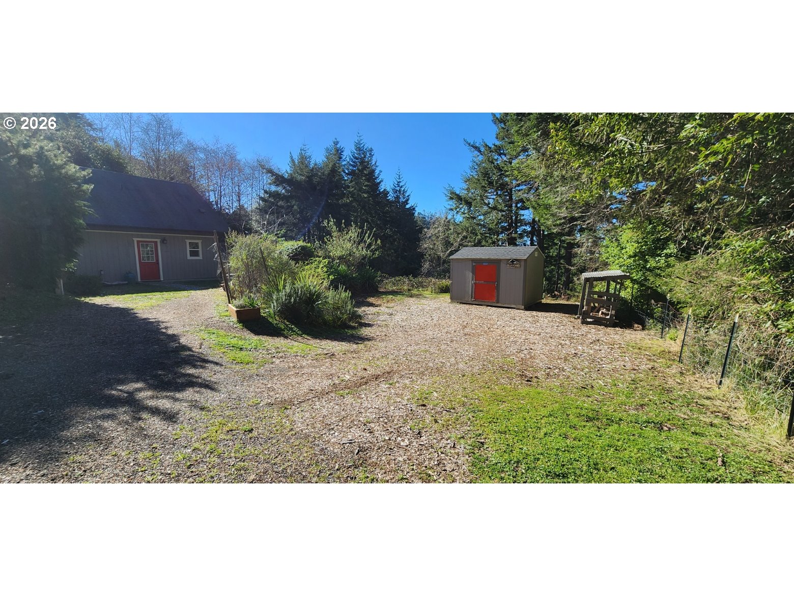94516 Riley Creek Way Gold Beach, OR 97444 - Photo 24 of 35 a view of a backyard with plants and brick wall
