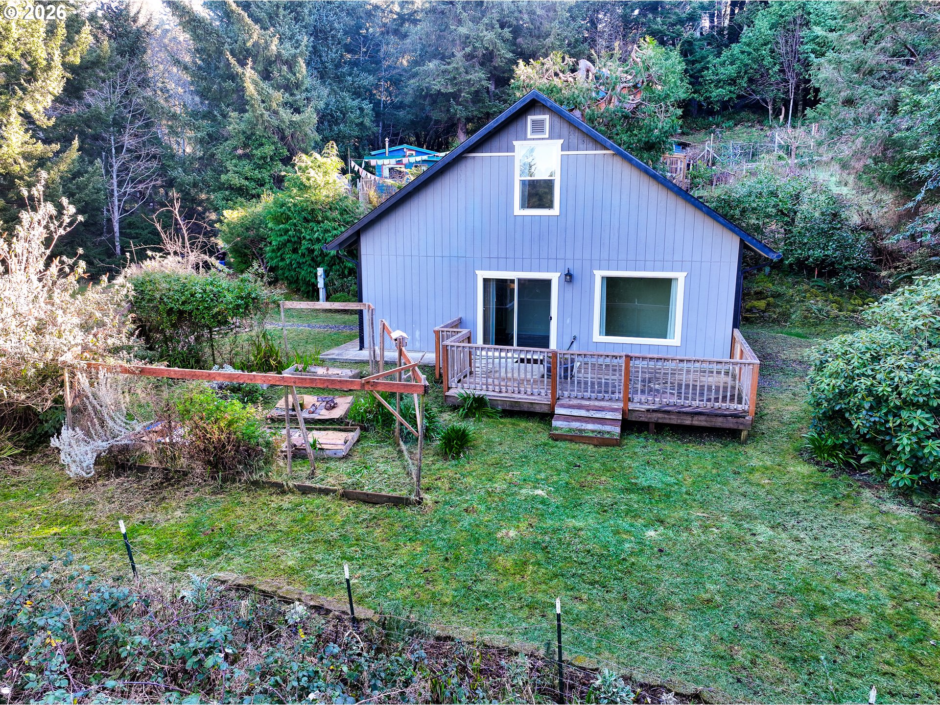 94516 Riley Creek Way Gold Beach, OR 97444 - Photo 31 of 35 a view of backyard of house with wooden deck and seating space