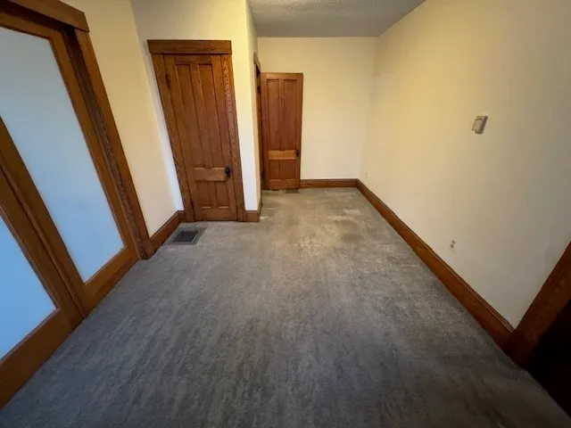 an empty room with wooden floor and closet