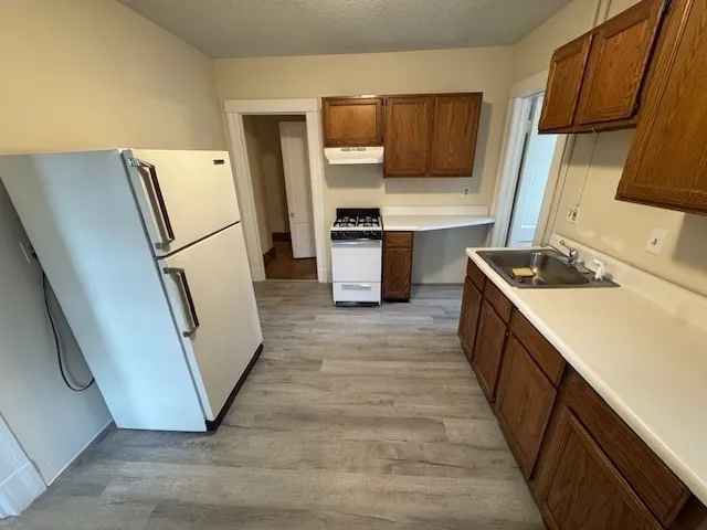 a kitchen with sink a refrigerator and washer