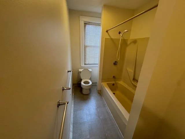 a bathroom with a tub shower vanity and a sink