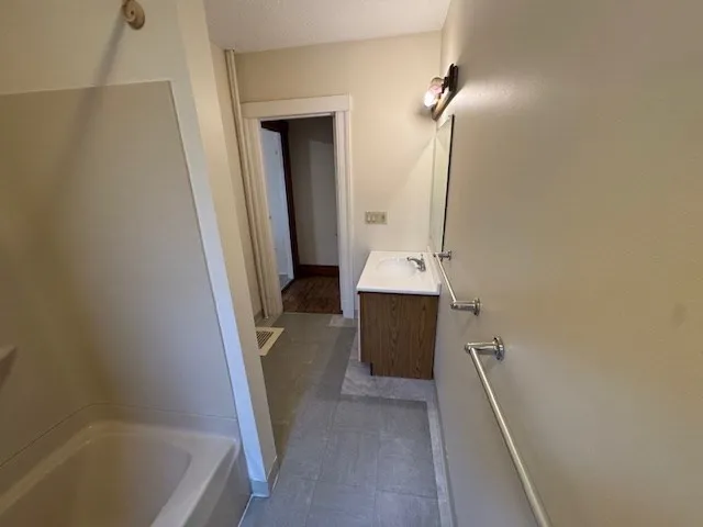 a bathroom with a tub sink and mirror