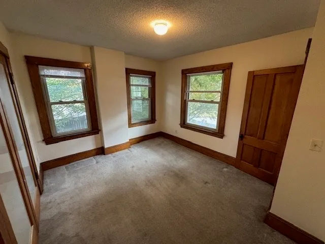 an empty room with windows and closet
