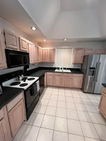 a kitchen with a sink a stove a microwave and cabinets