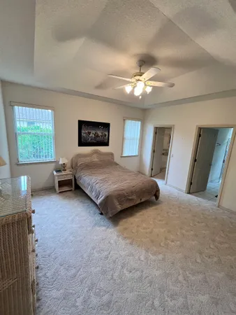 a spacious bedroom with a large bed and a chandelier