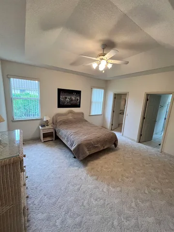 a spacious bedroom with a large bed and a chandelier