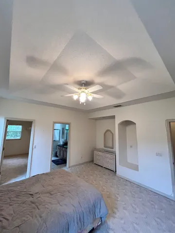 a spacious bedroom with a bed and dresser