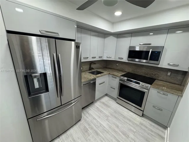 a kitchen with stainless steel appliances and a refrigerator