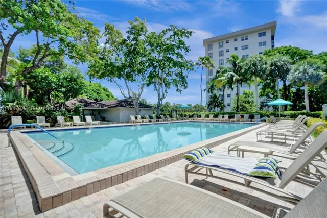 a view of a swimming pool with a patio and a yard