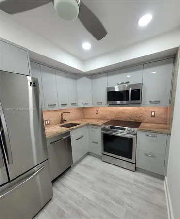 a kitchen with stainless steel appliances granite countertop a stove a sink and a refrigerator