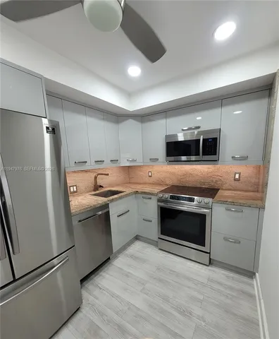 a kitchen with stainless steel appliances granite countertop a stove a sink and a refrigerator