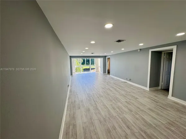 a view of empty room with wooden floor