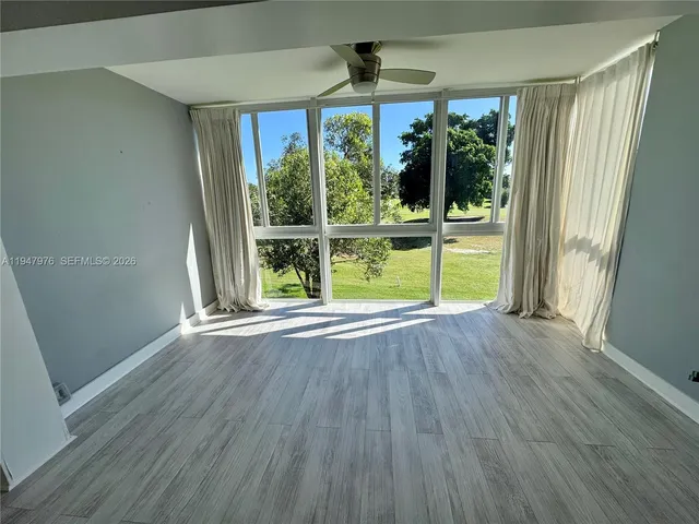 a view of empty room with wooden floor and outdoor view