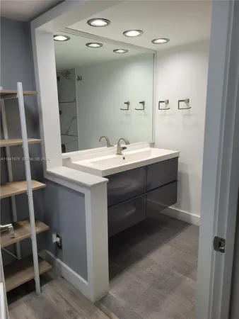 a bathroom with a sink a mirror and a shower