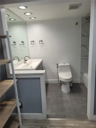 a bathroom with a sink toilet and a mirror