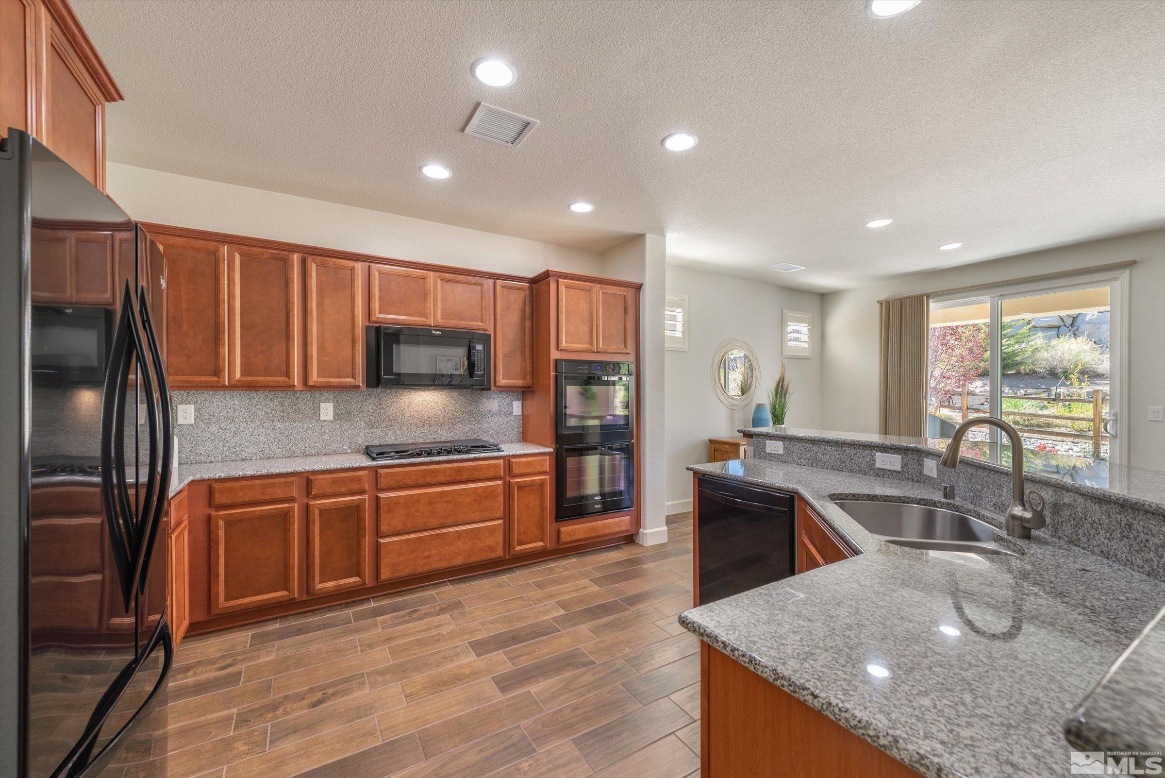 9207 Maplehurst Trail Reno, NV 89523 - Photo 15 of 40 a kitchen with stainless steel appliances granite countertop a sink stove and refrigerator