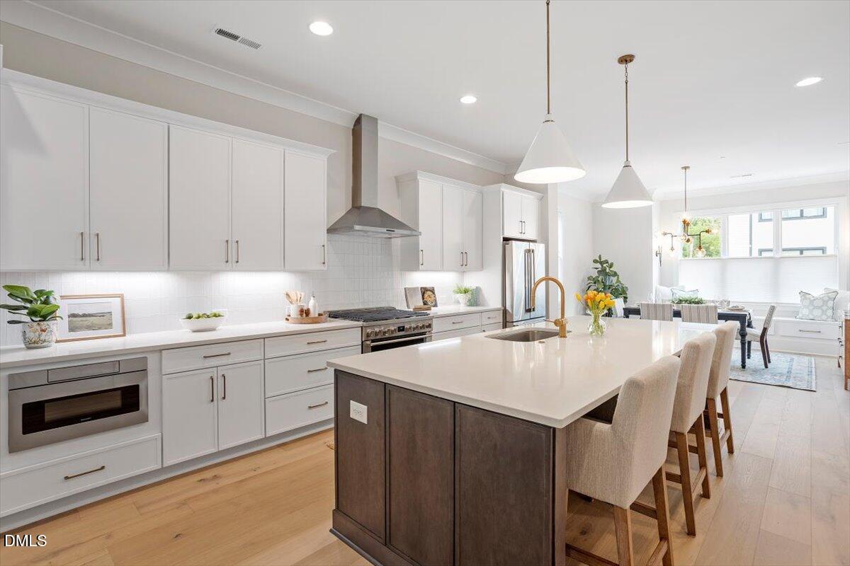 811 Maple Berry Lane, Unit 101 Raleigh, NC 27607 - Photo 5 of 45 a kitchen with a stove a sink a dining table and chairs