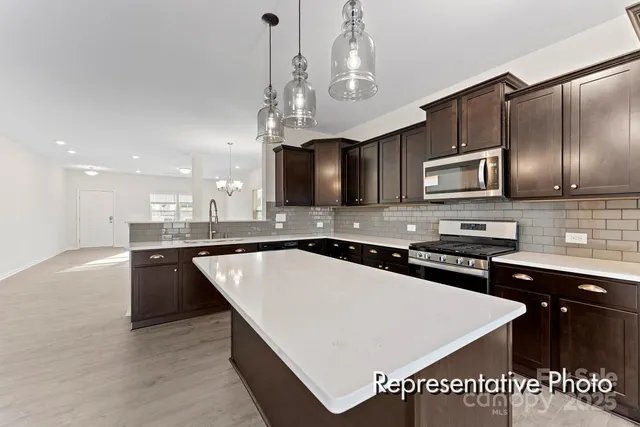 a kitchen with stainless steel appliances granite countertop a sink stove and microwave