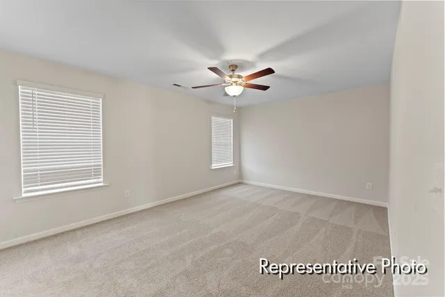 an empty room with windows and ceiling fan