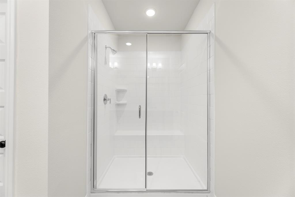 3916 Keya Drive Prosper, TX 75078 - Photo 23 of 28 a bathroom with a glass shower door