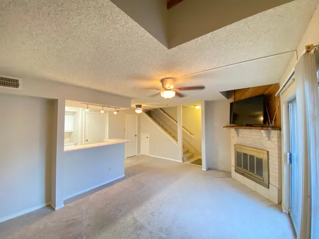 a view of a livingroom with an empty space and a fireplace