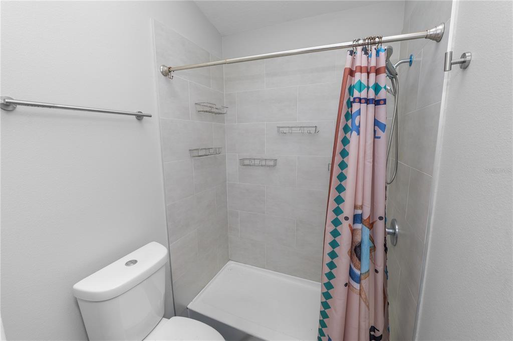 3307 Fox Ridge Drive Winter Haven, FL 33884 - Photo 15 of 27 a white toilet sitting next to a shower curtain