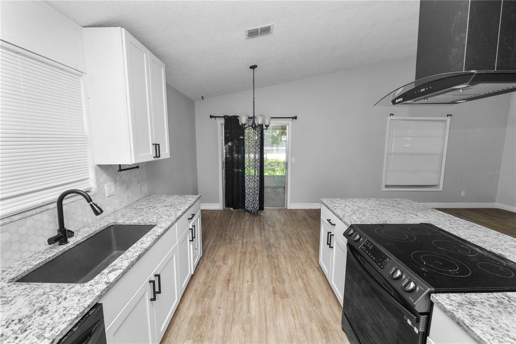 3307 Fox Ridge Drive Winter Haven, FL 33884 - Photo 7 of 27 a kitchen with granite countertop a sink stove and cabinets
