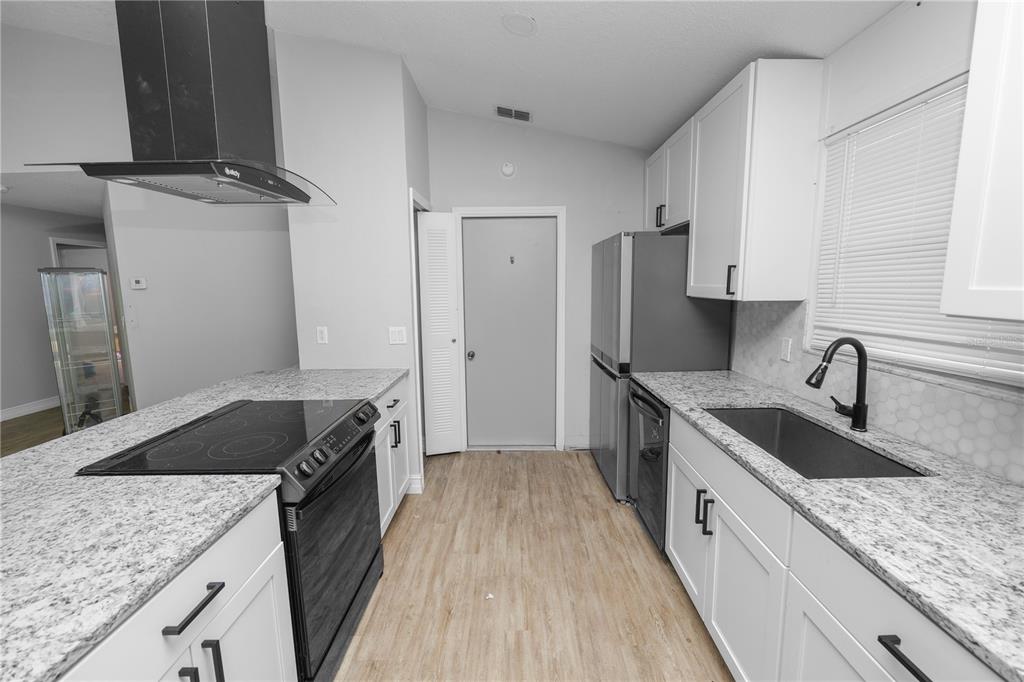 3307 Fox Ridge Drive Winter Haven, FL 33884 - Photo 8 of 27 a kitchen with granite countertop a sink stove and refrigerator