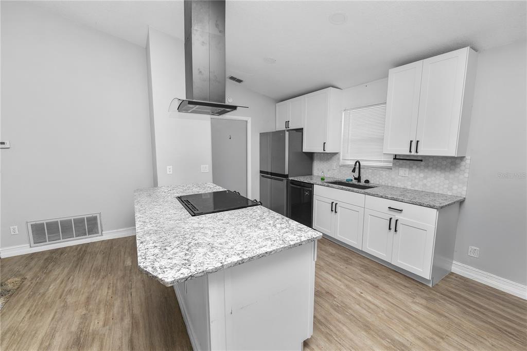 3307 Fox Ridge Drive Winter Haven, FL 33884 - Photo 9 of 27 a kitchen with a sink refrigerator and microwave