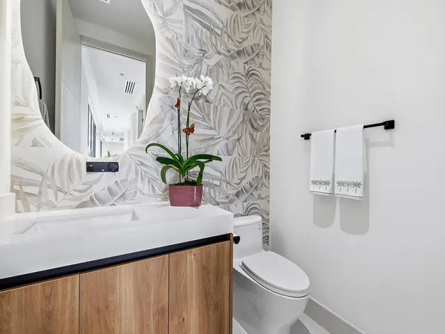 a bathroom with a sink a toilet and a mirror