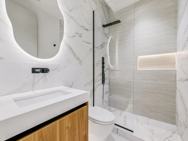 a bathroom with a sink a toilet and shower