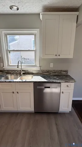 a kitchen with granite countertop white cabinets and white appliances