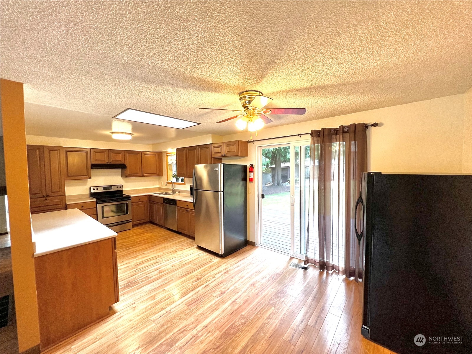 8 156th Place Southwest Bothell, WA 98012 - Photo 9 of 33 a view of a kitchen with kitchen island stainless steel appliances refrigerator sink and stove